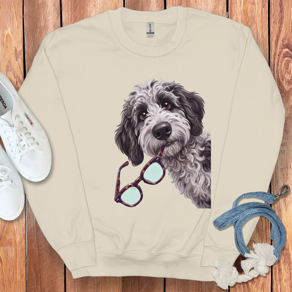 Beige crewneck sweatshirt featuring a graphic of a fluffy black and white dog holding glasses.