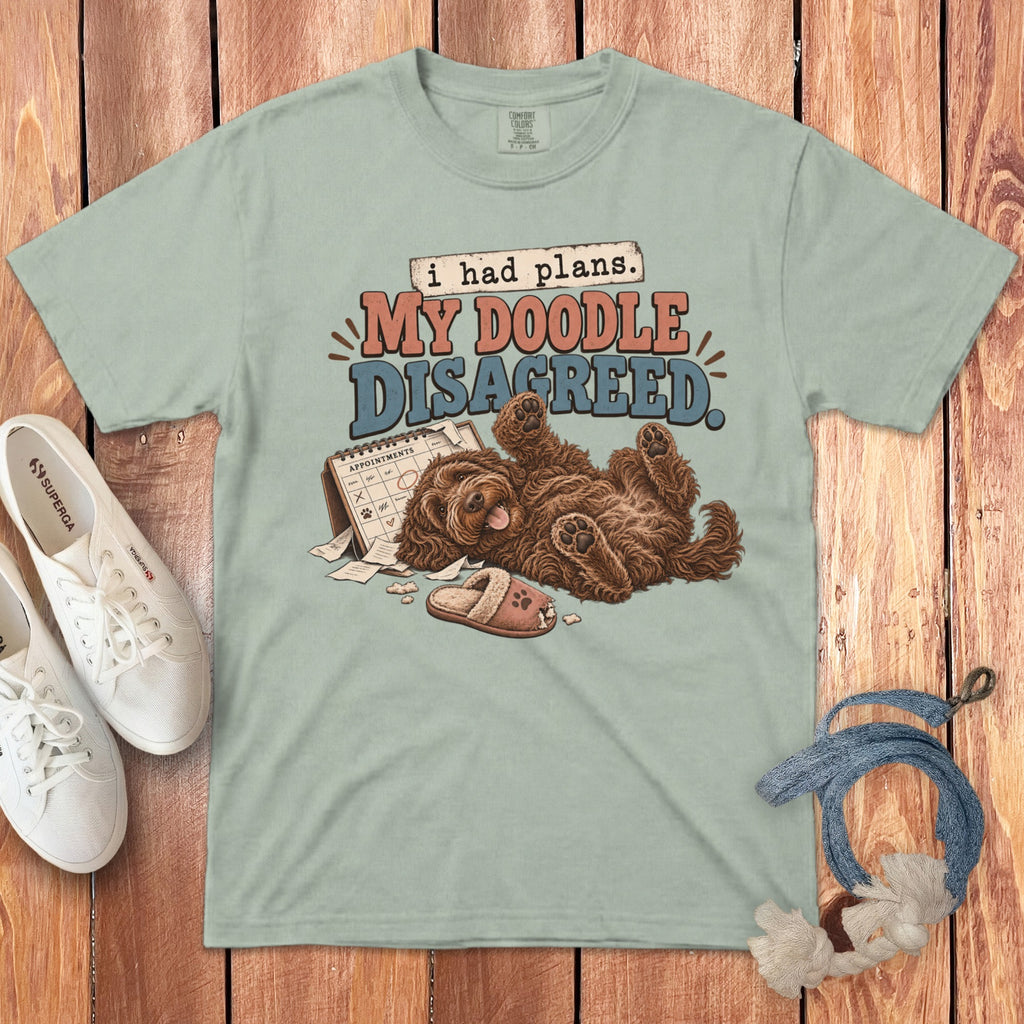 Sage green t-shirt with graphic reading My Doodle Disagreed, showing a brown doodle dog lying on its back.