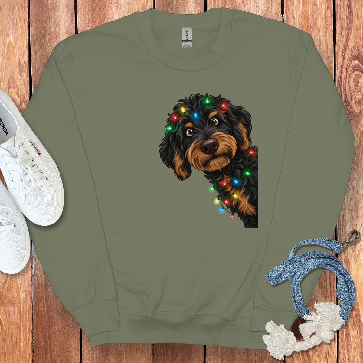 Green sweatshirt with a black and tan dog wearing colorful Christmas lights.