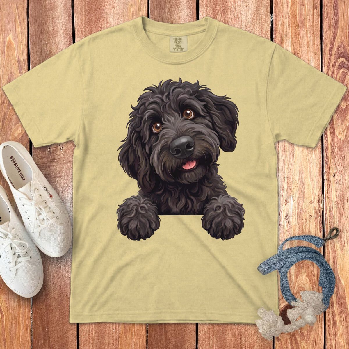 Pale yellow t-shirt with graphic of a black doodle dog peeking over.