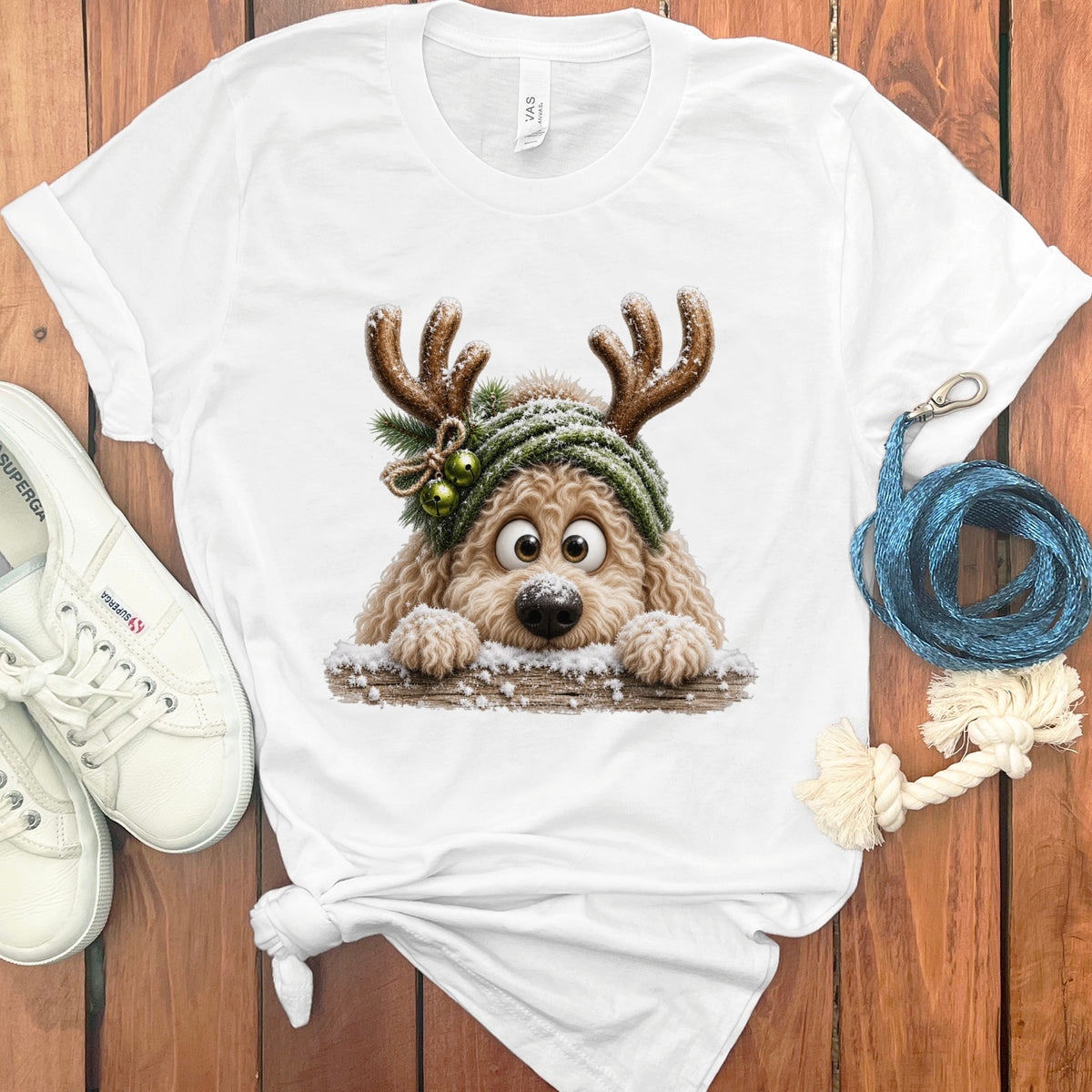 White t-shirt featuring a cartoon dog with antlers and a knitted hat.