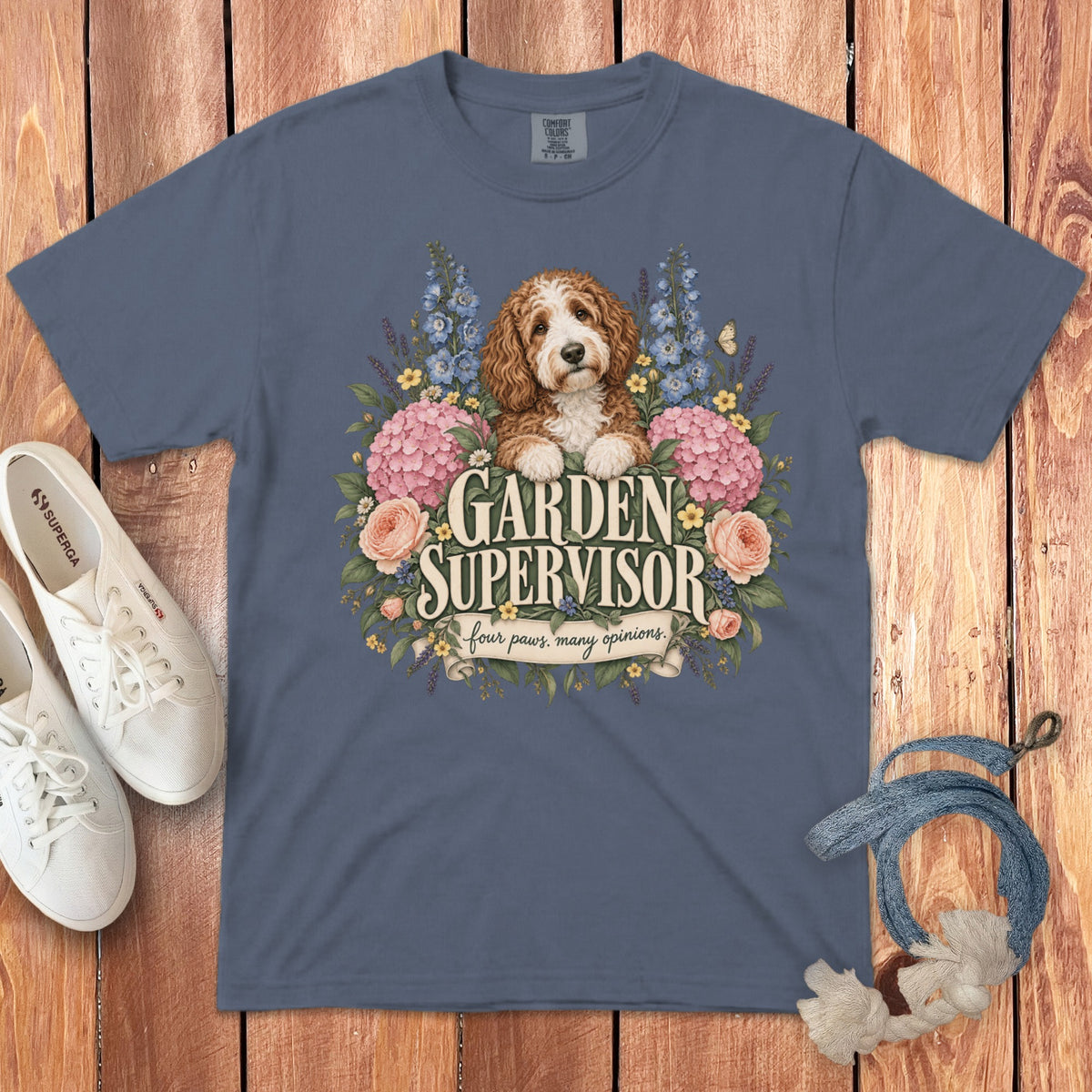 A slate blue crewneck t-shirt featuring a doodle dog surrounded by flowers and the text GARDEN SUPERVISOR.