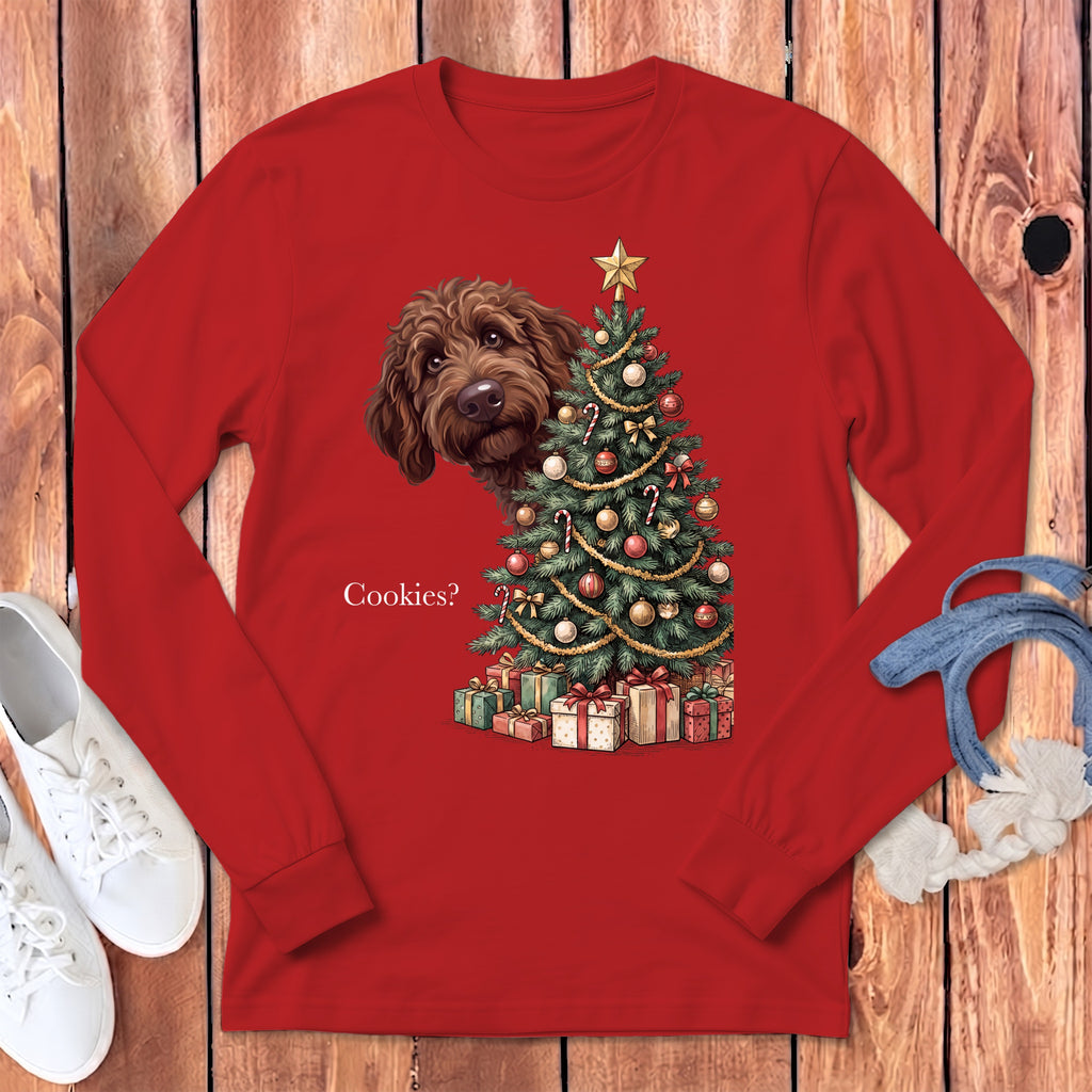 Red long sleeve shirt with a brown dog peeking over a Christmas tree and gifts.