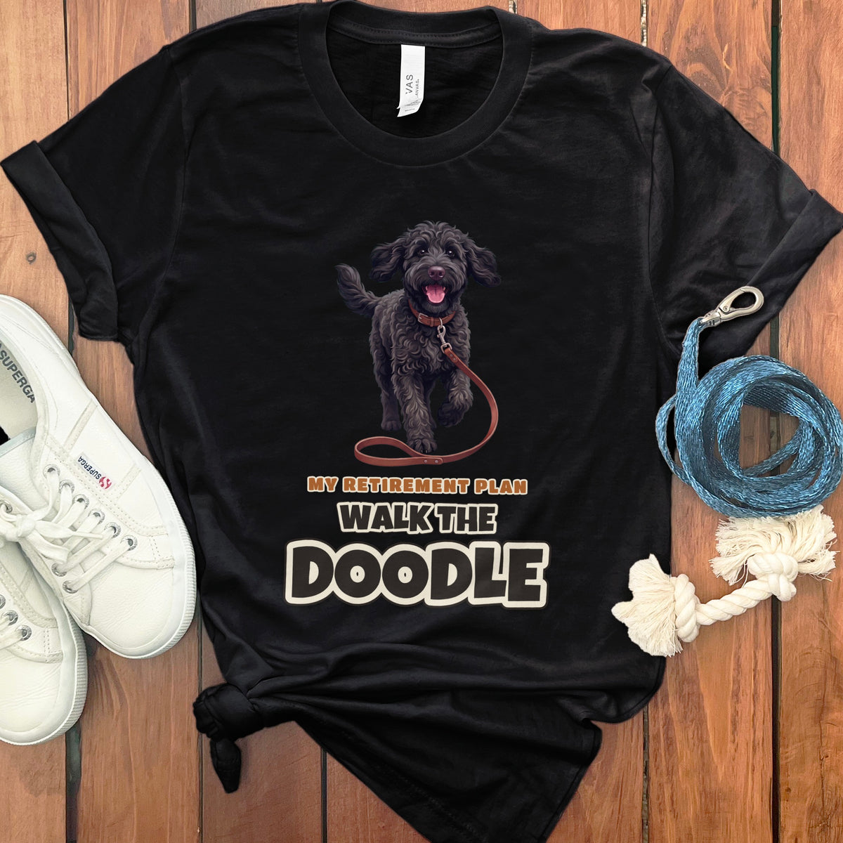 Black t-shirt with a black doodle dog graphic and text: "MY RETIREMENT PLAN WALK THE DOODLE".