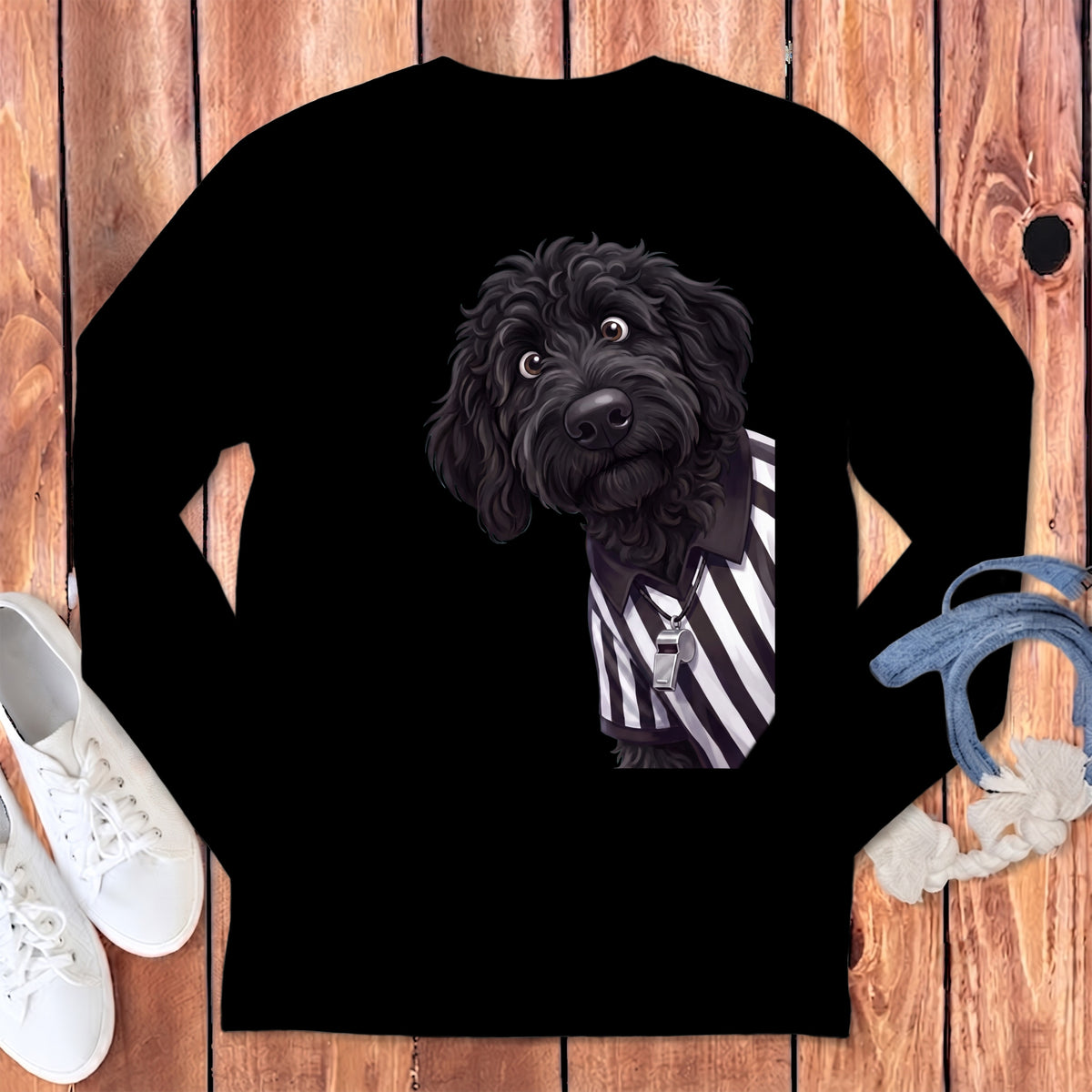 Black doodle dog wearing a referee shirt with a whistle on a string.